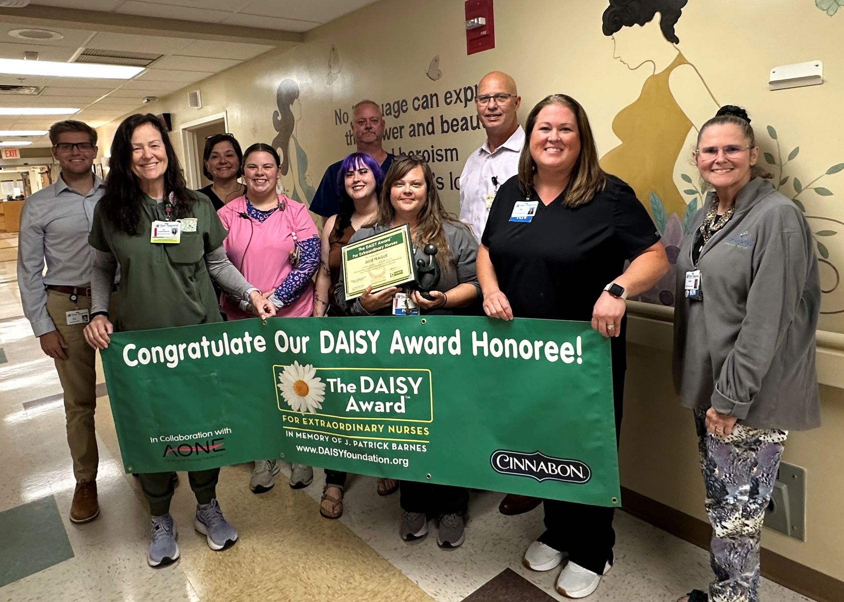 Julie Teague and colleagues_DAISY Award_07.24.26 web Hospital leaders and nurses pose with DAISY Award banner